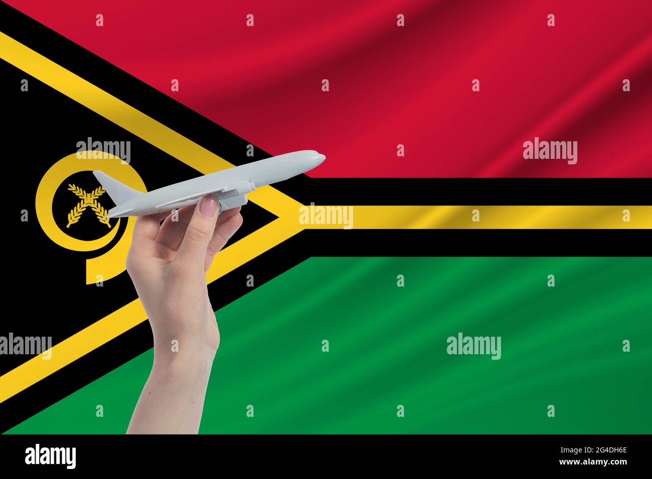 Airplane in hand with national flag of Vanuatu. Travel to Vanuatu. Stock Photo