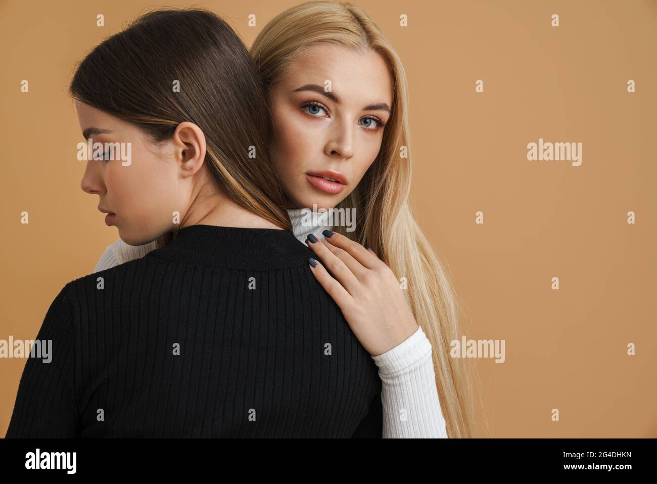 Two sensual attractive young women standing close to each other ...