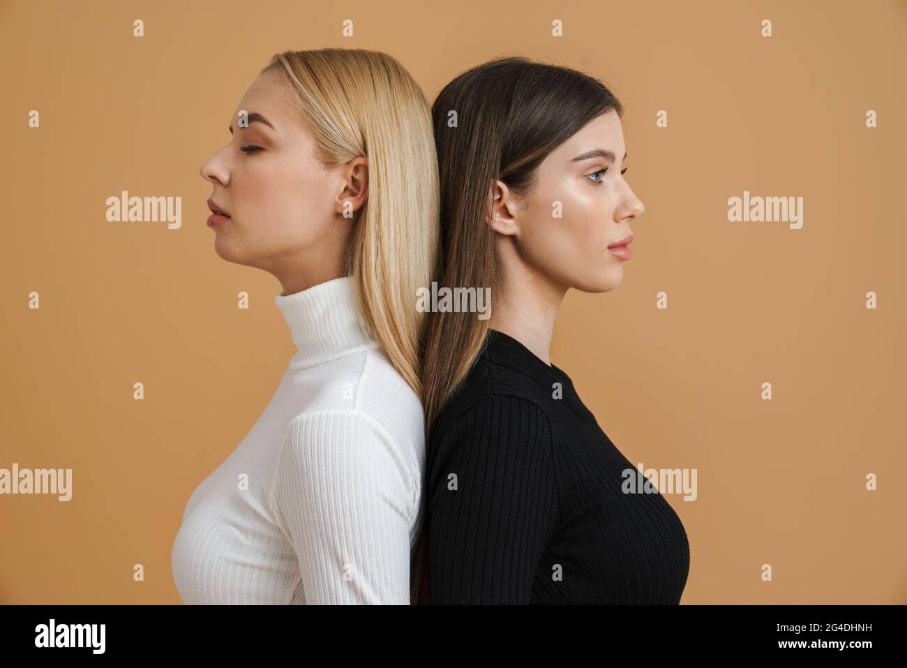 Two sensual attractive young women standing close to each other ...