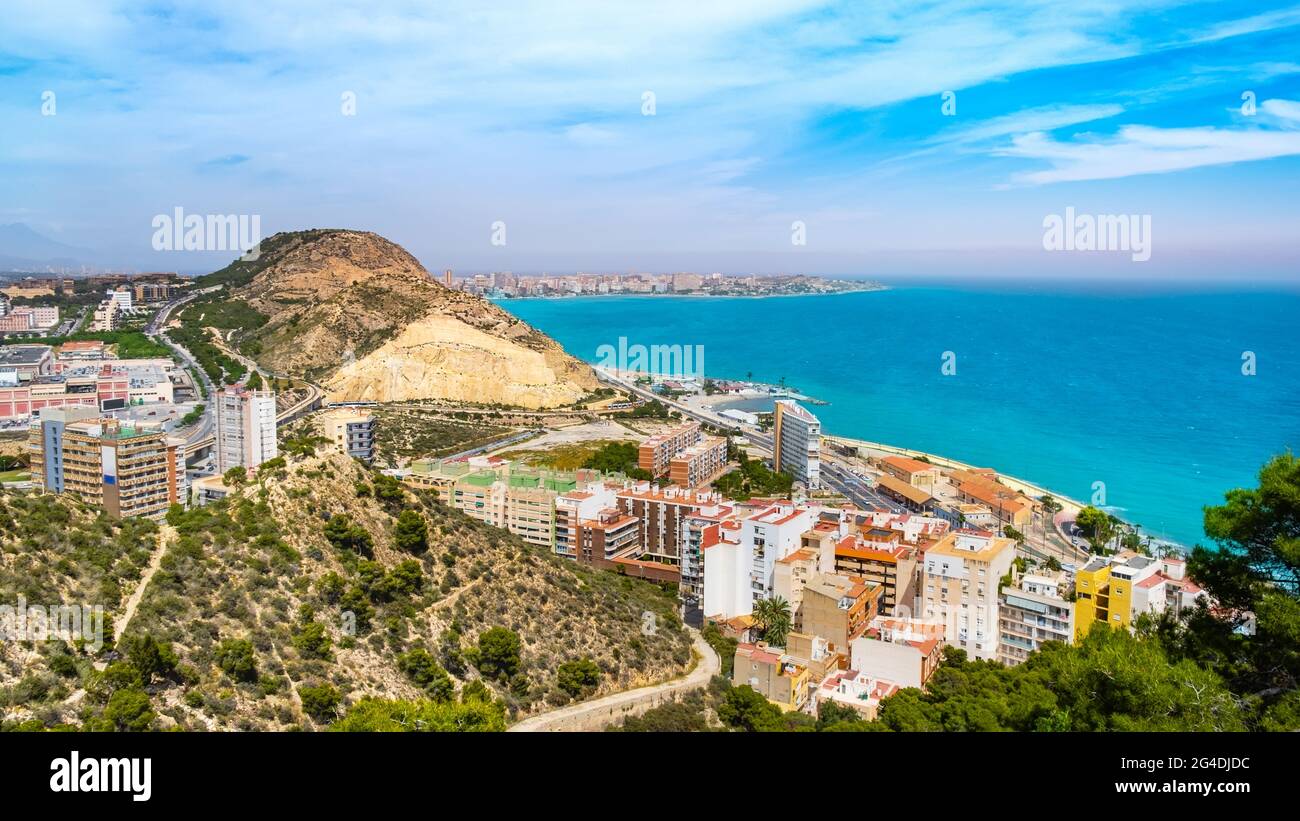Alicante town with Postiguet beach, Mediterranean sea, Serra Grossa mountain and Cabo de la Huerta district with high buildings, roads. Costa Blanca Stock Photo