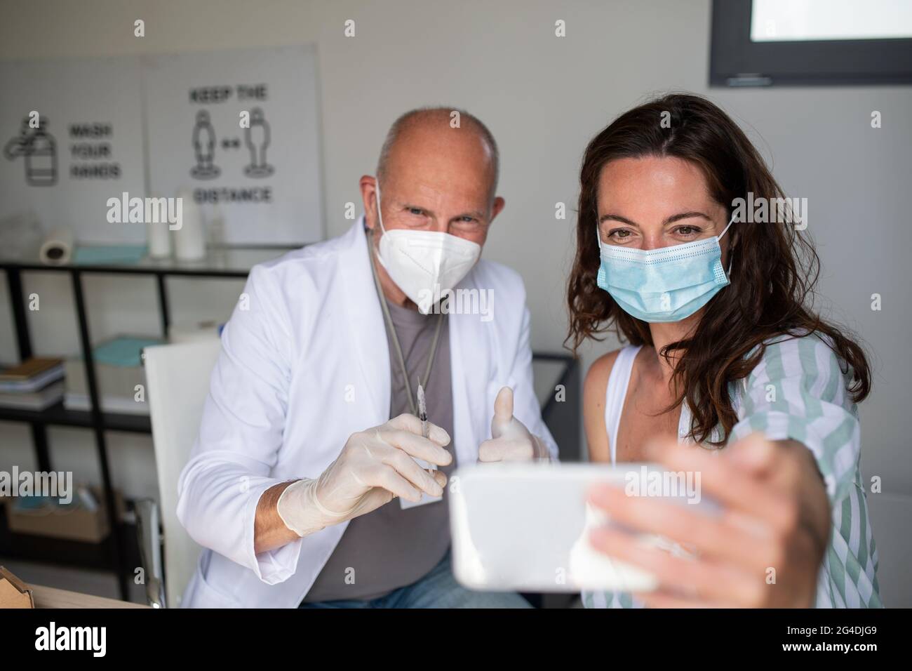 Happy young woman taking selfie with doctor, covid-9 vaccination concept. Stock Photo