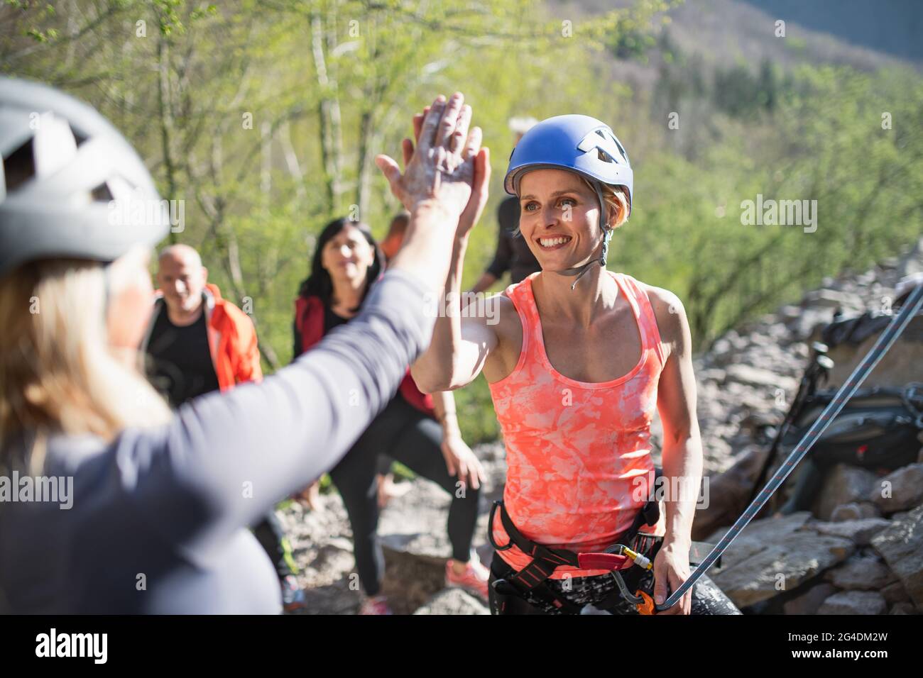 Group of seniors with instructor climbing rocks outdoors in nature ...