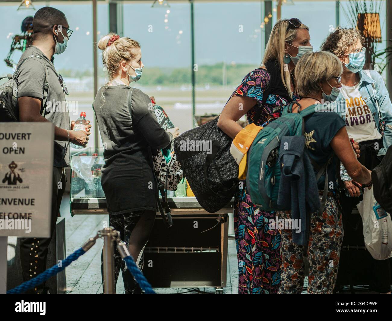 Passengers queue in a airport departure lounge. The passengers all