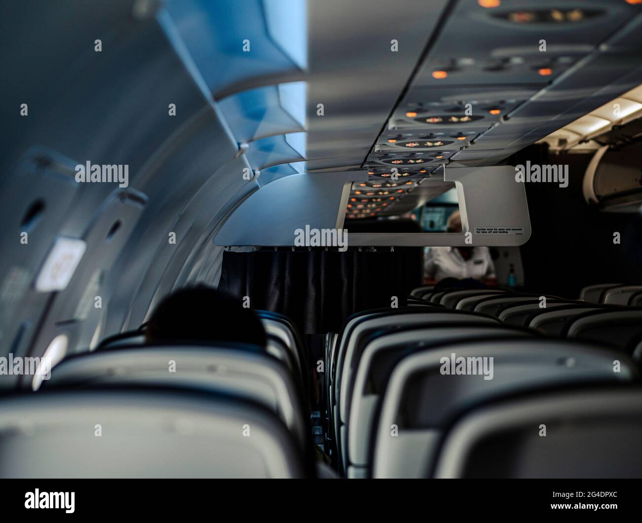 Interior of empty seats on a airplane. Only a few passengers sit in the empty plane during a flight in lockdown and corona virus travel bans. Stock Photo