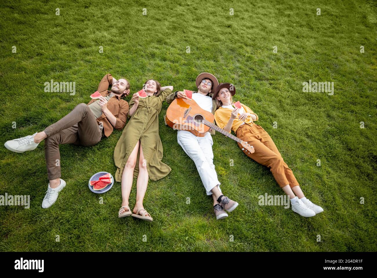 Friends lying together on the green lawn Stock Photo