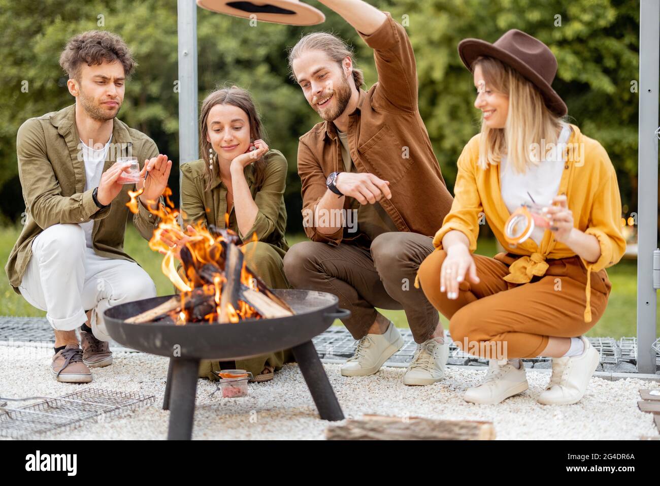 Group of young friends hang out by a fireplace at backyard Stock Photo