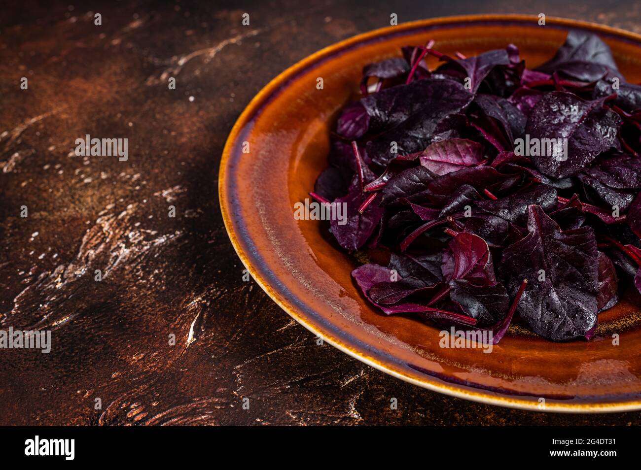 Raw Ruby or red chard salad Leafs on a rustic plate. Dark background. Top view. Copy space Stock Photo