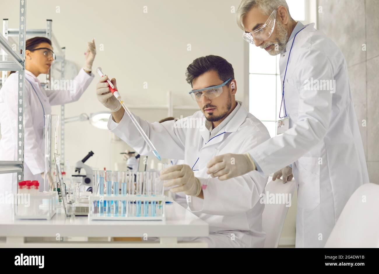 Group of serious medical scientists doing scientific research in modern laboratory Stock Photo