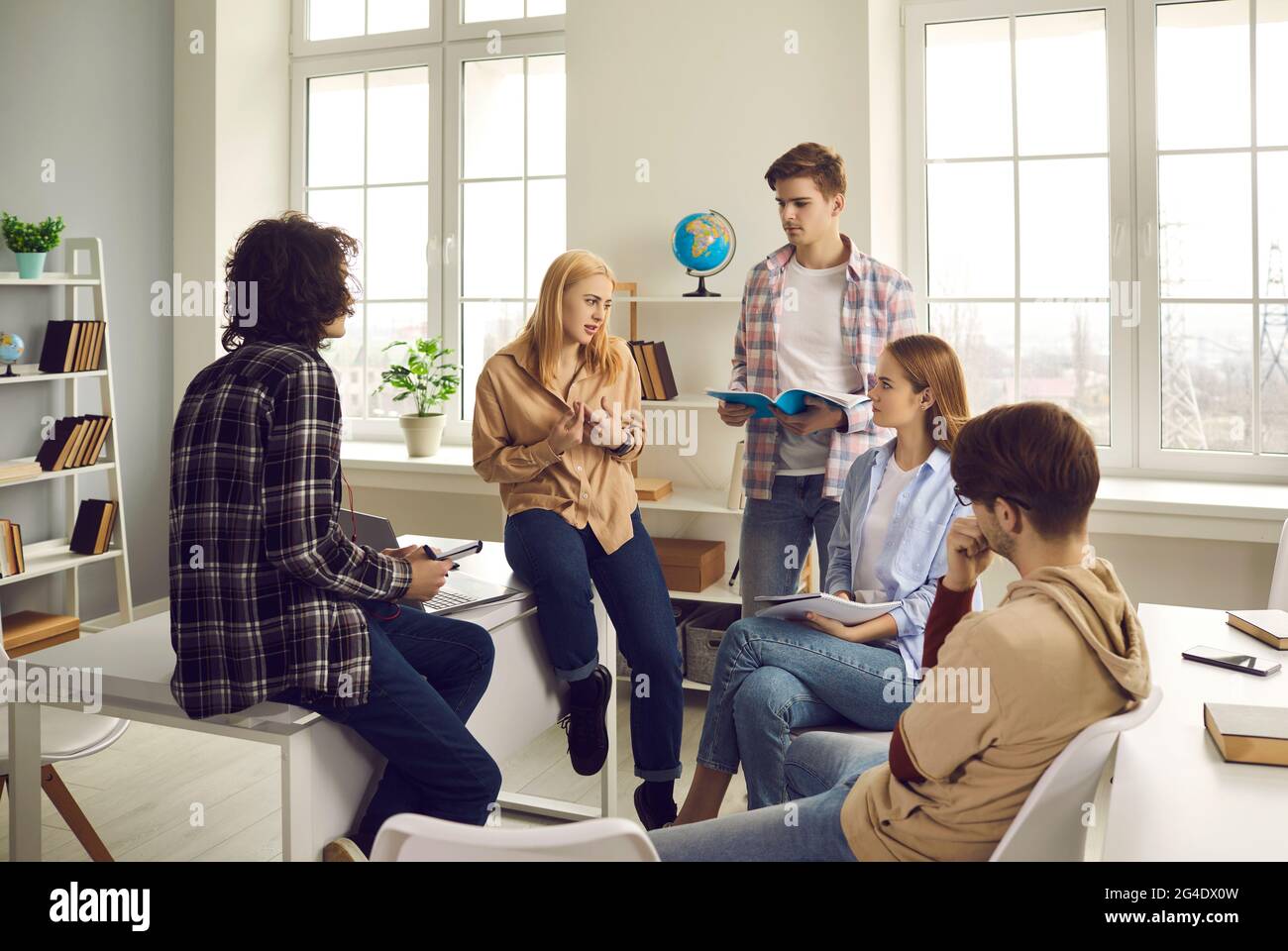 Teenage diverse classmates group talking sharing knowledge in classroom Stock Photo
