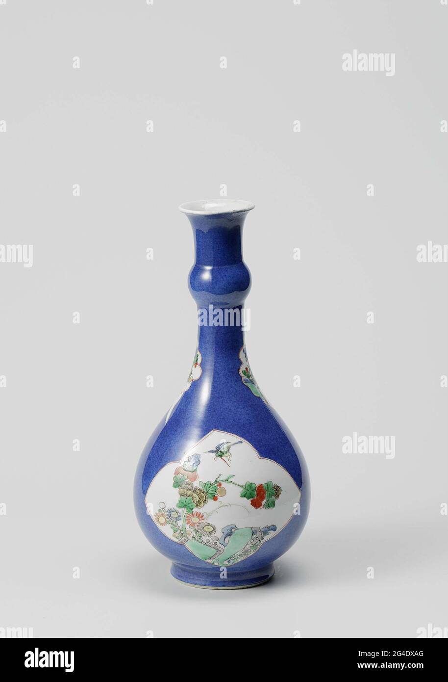 . Bottle-shaped vase of porcelain with a pear-shaped body and annular thickening in the neck and spreading mouth, painted in underglaze blue and on the glaze blue, red, green, yellow, aubergrine, black and gold. On the wall Two crafted fours with flowering plants (peony, aster) at a rock with a flying kingfisher or butterfly. On the neck two leaf-shaped cartouches with blooming plants. Bleu poudré with famille verte. Stock Photo