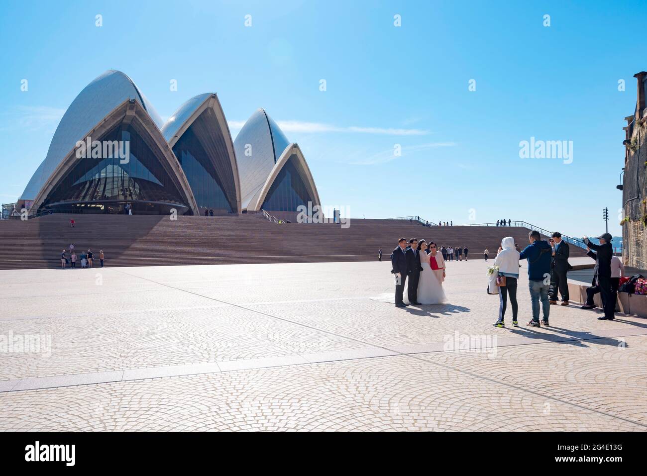 A bride and groom with family members being photographed on the forecourt of the Sydney Opera House in Australia Stock Photo