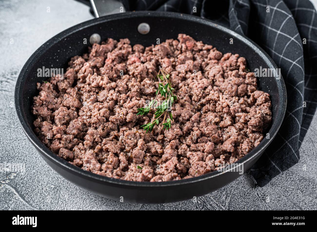 Fried mince beef and lamb meat in a pan with herbs. White background
