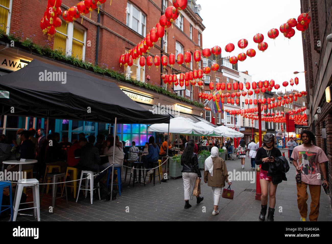London, UK, 20 June 2021: the streets of Chinatown are busy with customers and despite cloudy weather many people prefer to eat outdoors. Anna Watson/Alamy Stock Photo