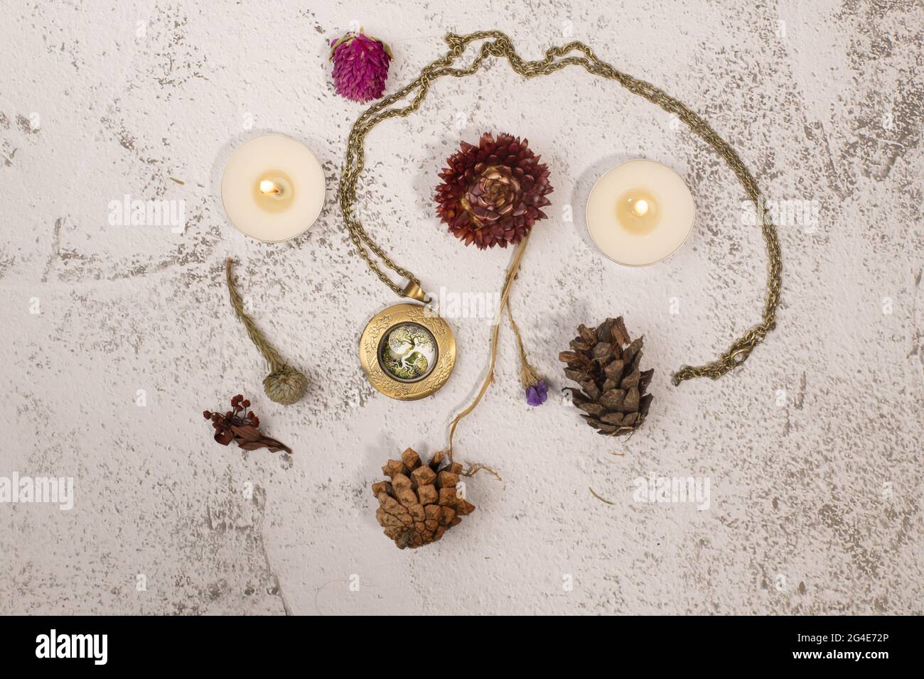 Flatlay with medallion, candles and dried flowers Stock Photo
