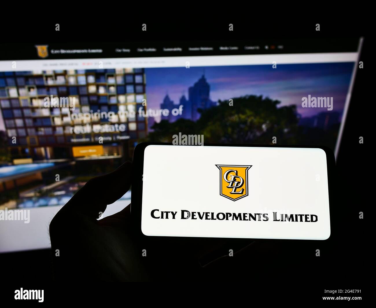 Person holding smartphone with logo of Singaporean property company