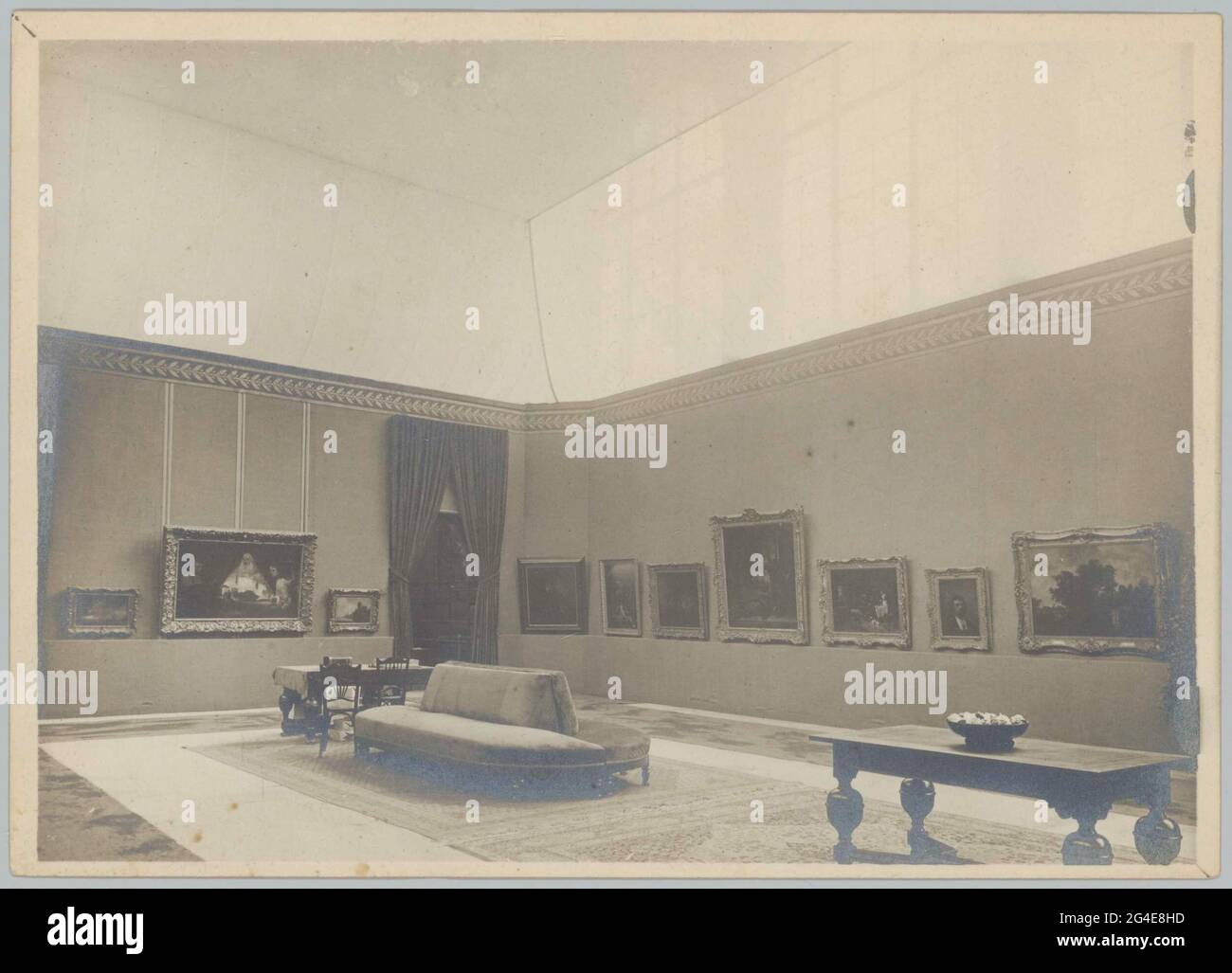 Room with paintings, furniture and curtains next to a passage