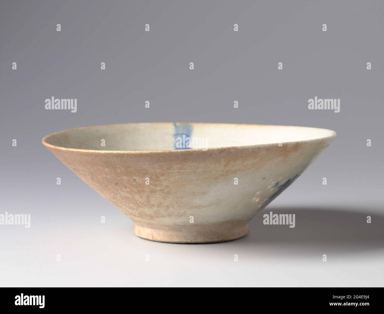 . Iranian potters admired the porcelain imported from China. From the 12th century they began using a new material, quartz paste fritware: white clay ground with fine quartz and glass powder. It allowed them to throw much thinner walls. They were trying to approximatethe translucency of Chinese porcelain. Sometimes, as with this bowl, they made perforations and used a transparent glaze to enhance this effect. Stock Photo