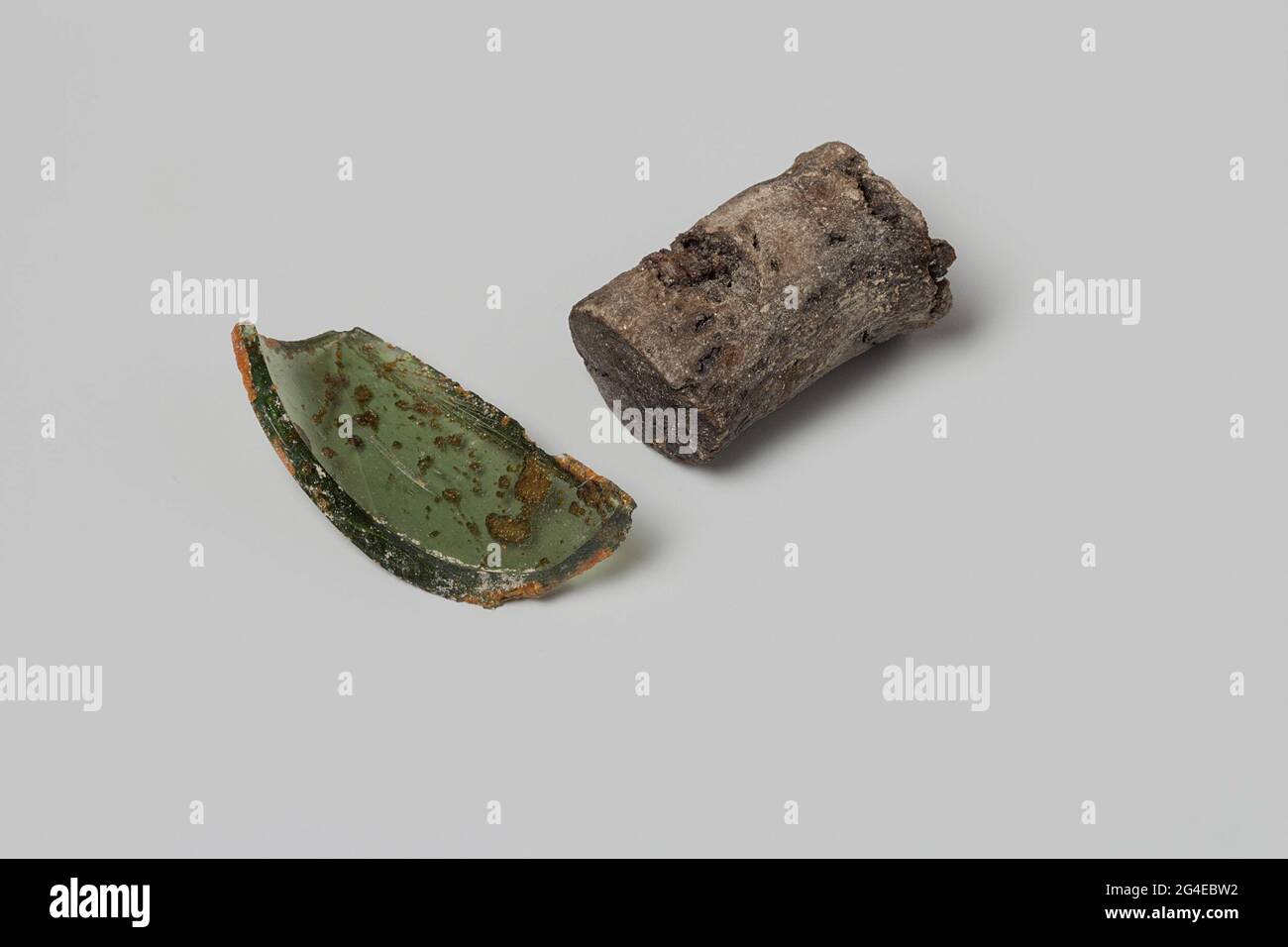 Glass shard and cork from a wine bottle from the wreck of the East Indies Flying Heart. The brown cork and the green glass fragment ever part of a wine bottle. Stock Photo