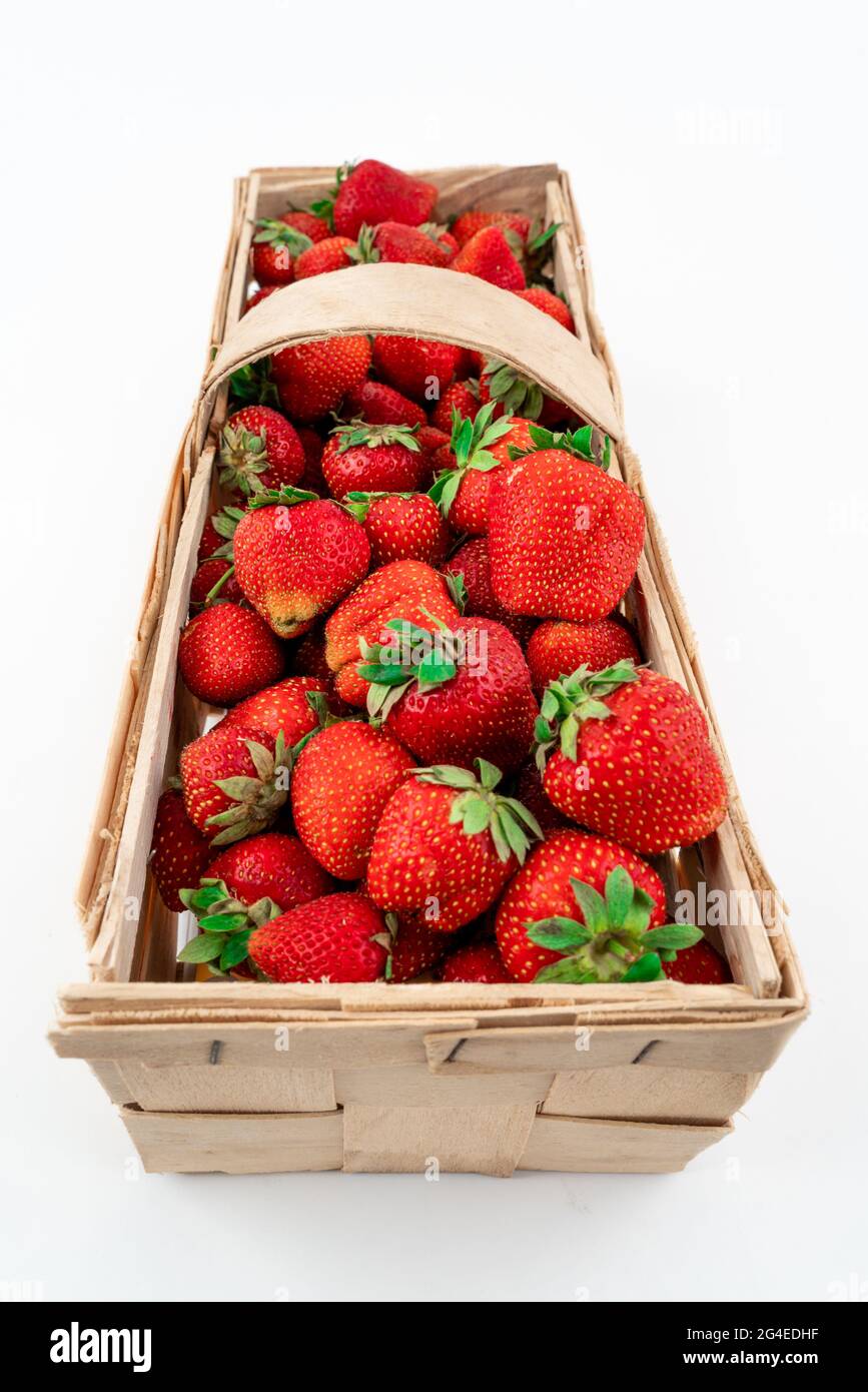 Wide angle shot of a wooden box full of red ripe strawberries isolated ...