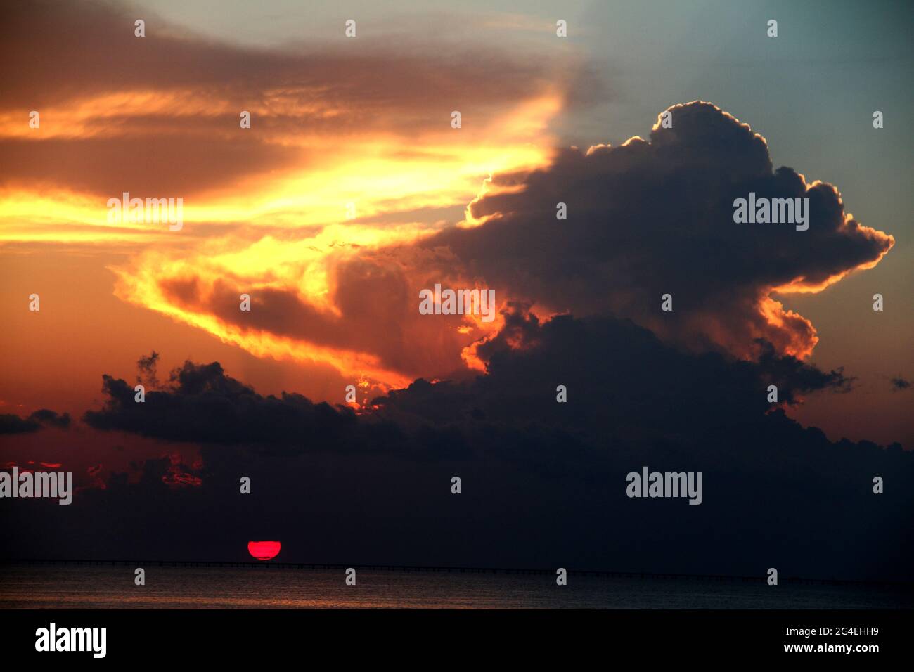 Beautiful colors in the sky as the sun sets behind a large cloud Stock ...
