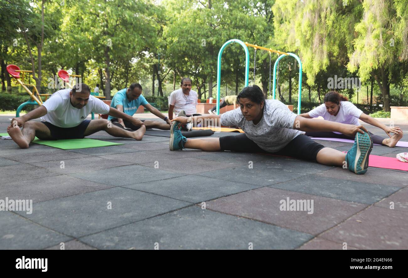 Indian people perform Wide Angle Seated Forward Bend Pose (Upavistha Konasana) yoga postures, to mark the International Yoga Day during the coronavirus pandemic at the District Park.Yoga Day is celebrated across the globe to highlight the importance of Yoga and it help in to keep our body and mind healthy. The International Yoga has been celebrated annually on 21 June, following its inception in the United Nations General Assembly in 2014. The theme for the International Yoga Day 2021 is decided by the UN Yoga for well-being. Stock Photo