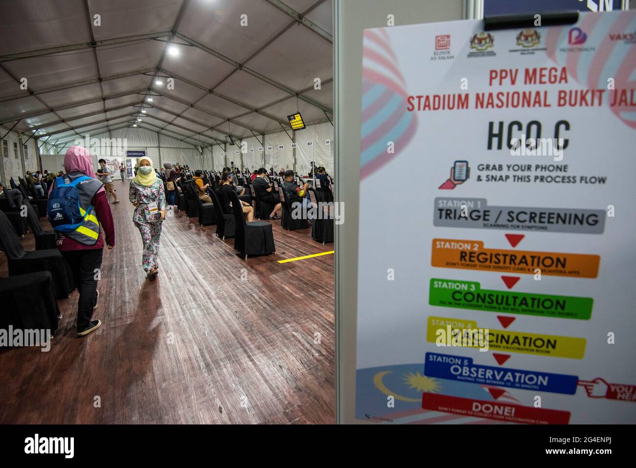 Kuala Lumpur, Malaysia. 21st June, 2021. People wait before they leave after receiving COVID-19 vaccines at the Bukit Jalil National Stadium vaccination center in Kuala Lumpur, Malaysia, on June 21, 2021. Malaysia reported another 4,611 new COVID-19 infections, bringing the national total to 701,019, the health ministry said on Monday. Credit: Chong Voon Chung/Xinhua/Alamy Live News Stock Photo