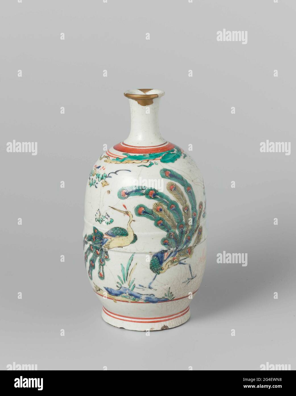 . Bottle (sakefles) of porcelain with a narrow, slightly spreading neck, painted on the glaze in blue, red, green, yellow and black. On the abdomen twice a peacock at a rock with a flowering plant. Leaves and red lines on the shoulder. Golden lacquer repair in the edge. Arita (Kakiemon-style). Stock Photo