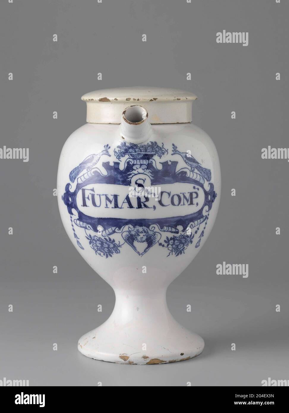 . Pharmacist spot from faience. With ear and spout and blue painted label with inscription: S, / Fumar, comp,. Stock Photo