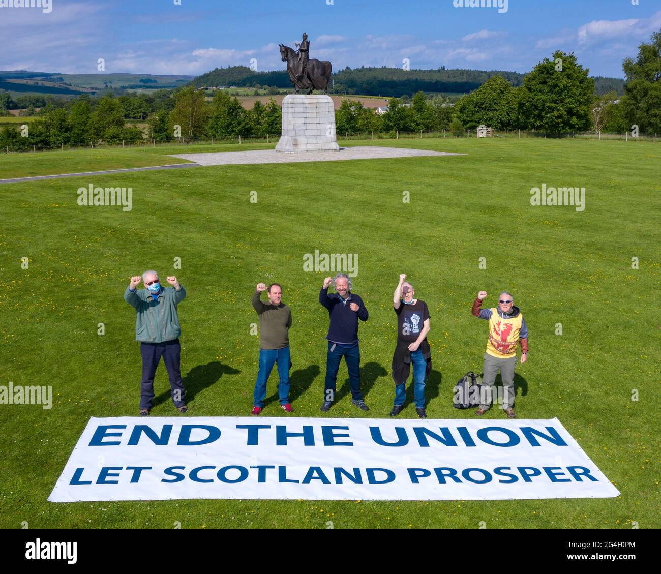 Battle of Bannockburn site, Stirling, Scotland, UK. 21st June, 2021. PICTURED: Sean Clerkin of Action for Scotland, (seen wearing black T-shirt) seen with fellow protestors at the site of the Battle of Bannockburn in front of the Robert the Bruce statue with a large protest banner which reads, ‘END THE UNION LET SCOTLAND PROSPER' in large capital letters. Pic Credit: Colin Fisher/Alamy Live News Stock Photo