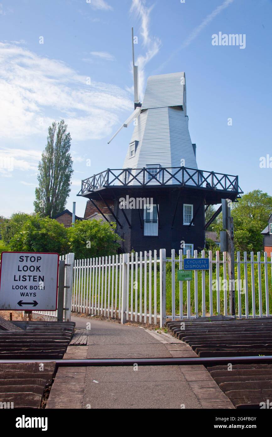 The windmill, with the Marshlink Ashford to Hastings rail line in foreground, at Rye in Kent, England.  June 2021 Stock Photo
