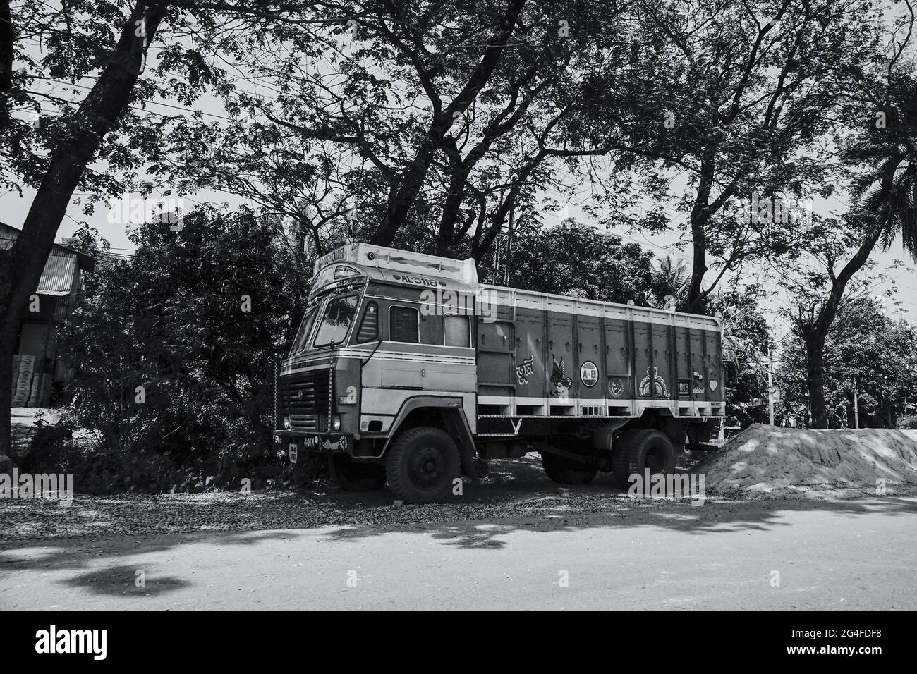 HOWRAH, WEST BENGAL, INDIA - FEBRUARY 24TH, 2018 : A goods carriage truck is carrying goods on the highway in daytime. Black and white image. Stock Photo