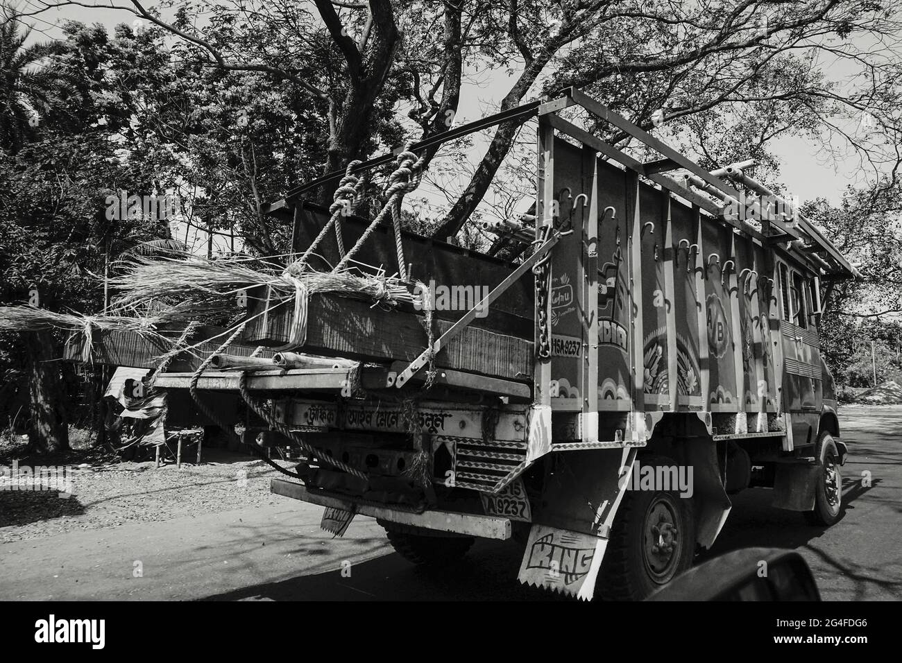 HOWRAH, WEST BENGAL, INDIA - FEBRUARY 24TH, 2018 : A goods carriage truck is carrying goods on the highway in daytime. Black and white image. Stock Photo