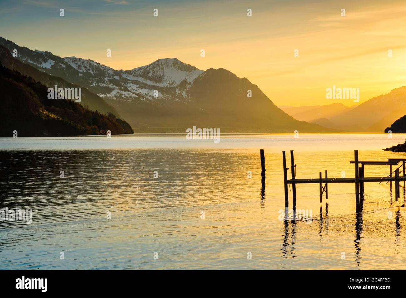 Lake with mountains in the background, view from Brunnen over Lake Lucerne at sunset with footbridge in the foreground, Canton Schwyz, Switzerland Stock Photo