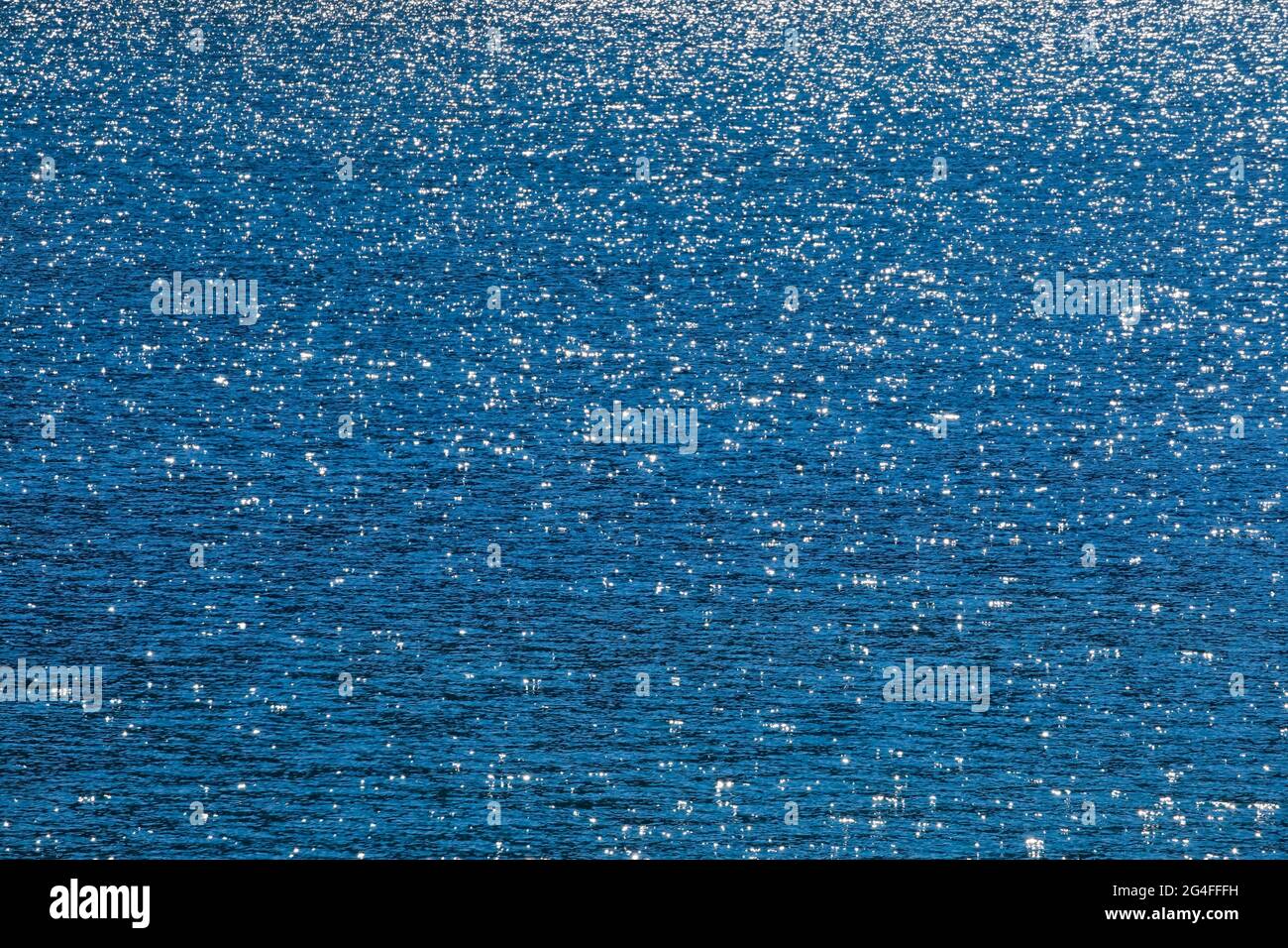 Sunbeams reflect glittering on the water surface of the Vierwaldstaettersee and form an abstract pattern Stock Photo