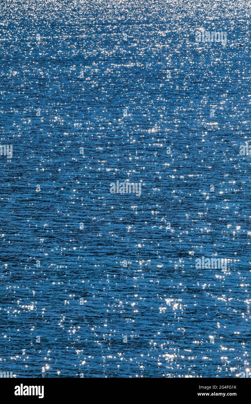 Sunbeams reflect glittering on the water surface of the Vierwaldstaettersee and form an abstract pattern Stock Photo