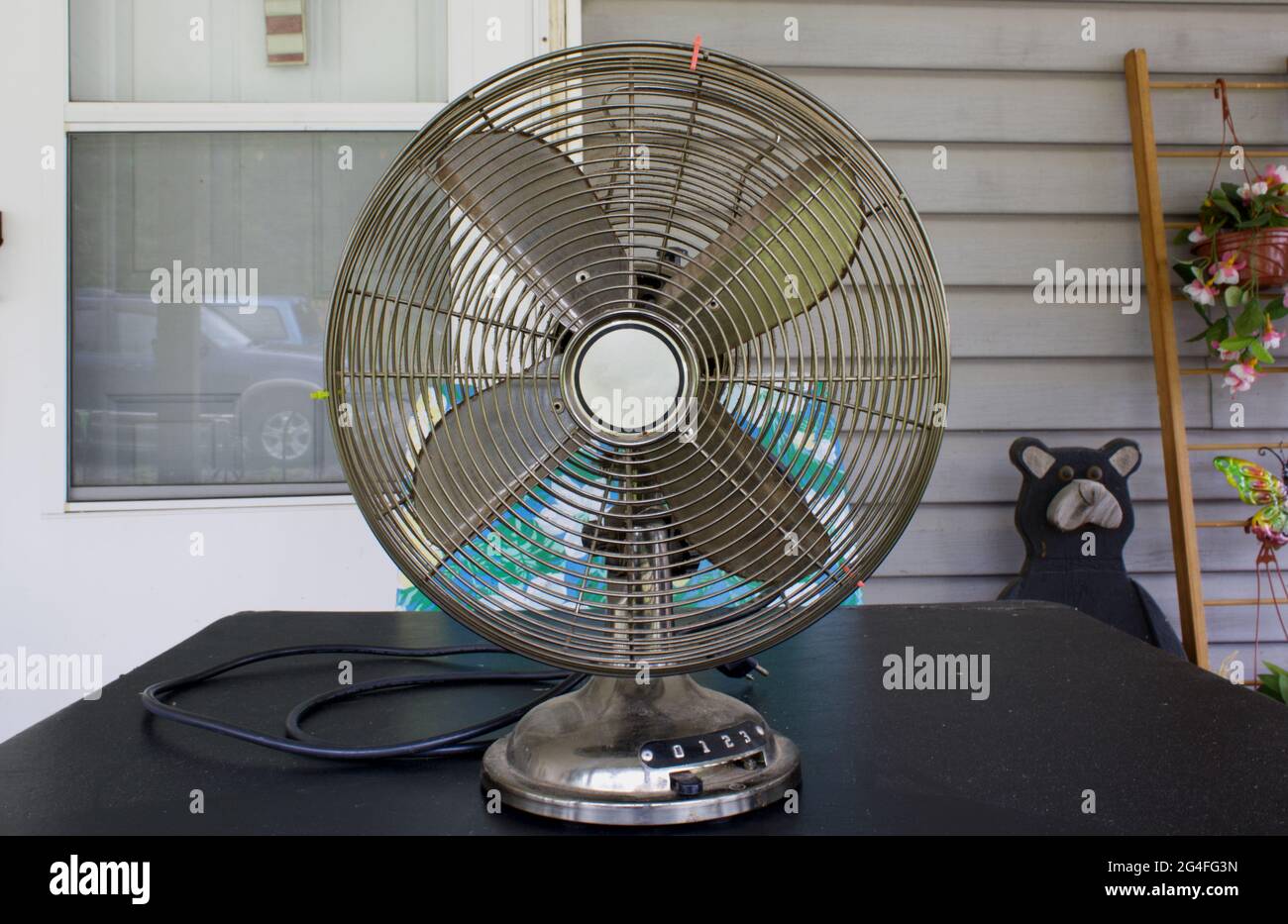 An Old Style Oscillating Fan on a Table Outdoors Stock Photo