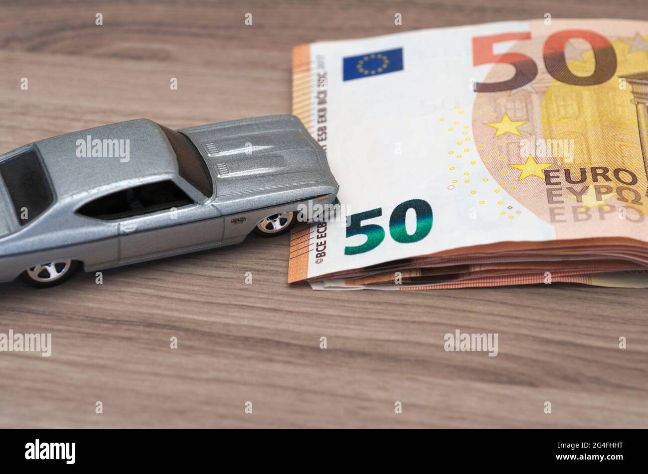 toy car rides up a stack of  fifty euro banknotes Stock Photo