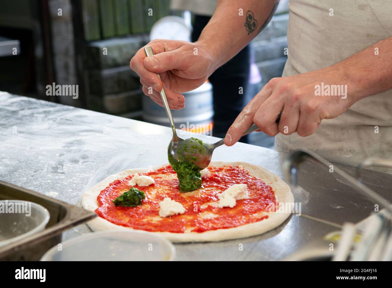 Coronavirus stories from the food industry. A pizza base gets prepare before hitting the outdoor wood ovens at The Moorcock Inn (owned by Aimee Turfor Stock Photo