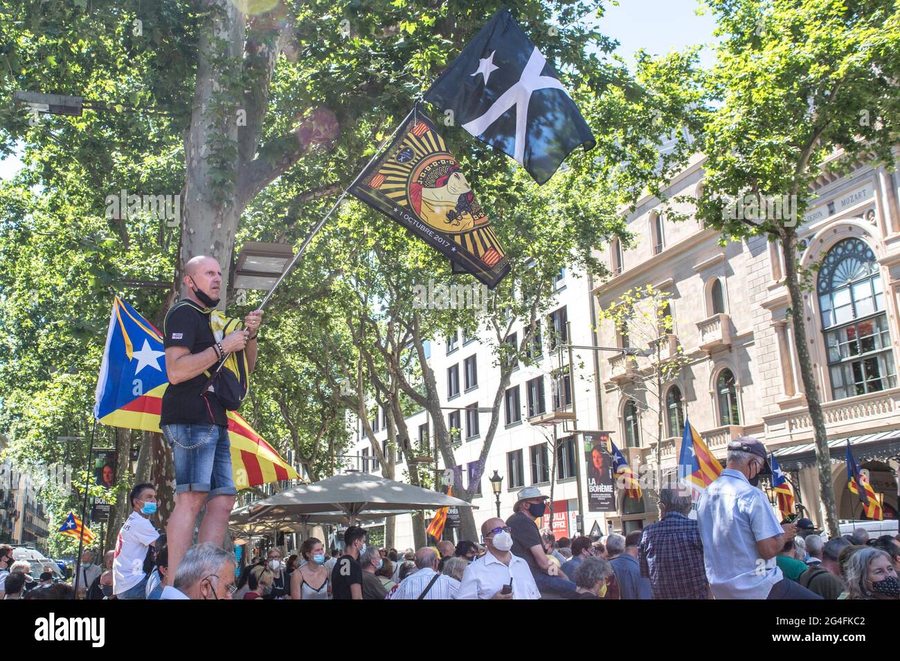 June 21, 2021, Barcelona, Catalonia, Spain: Protester is seen with Catalan independence flags.Hundreds of Catalan independentistas have demonstrated this Monday, June 21, in Las Ramblas in Barcelona, in front of the Gran Teatre del Liceu (Great Theater of the Lyceum), shielded by many policemen, to protest the visit of the President of the Spanish Government, Pedro Sanchez, who has held a conference entitled ''Reunion: a project for the future for all of Spain'', with the expectation of an imminent granting of pardons for the independence leaders in prison. The protesters protested to denounc Stock Photo