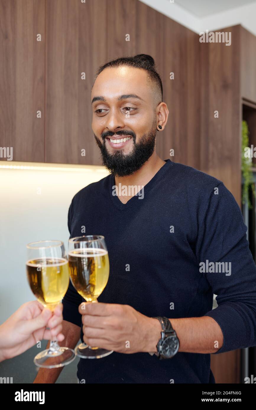 Portrait of handsome bearded man clinking glasses with girlfriend when ...