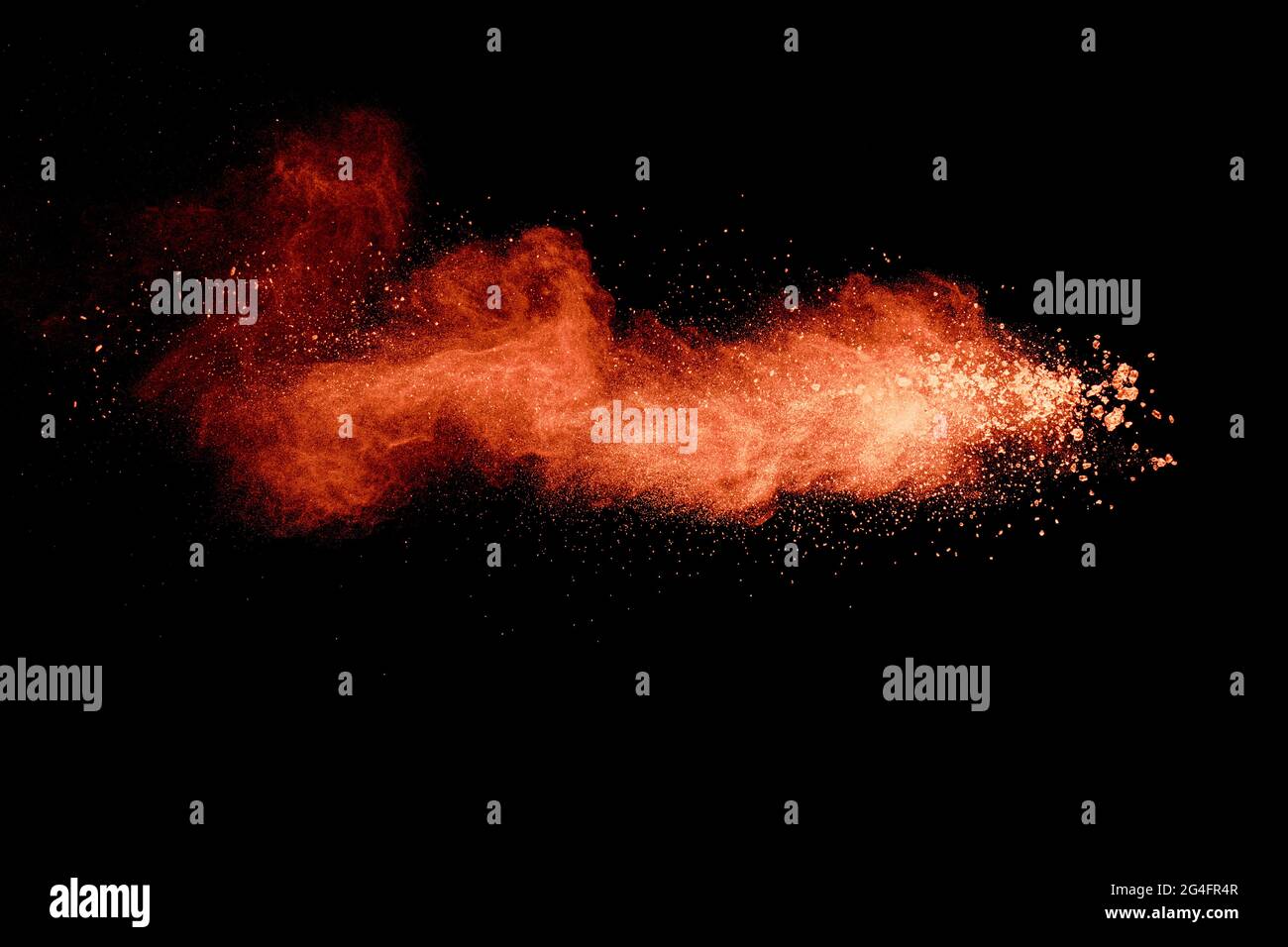 Abstract orange powder explosion on black background. Freeze motion of ...
