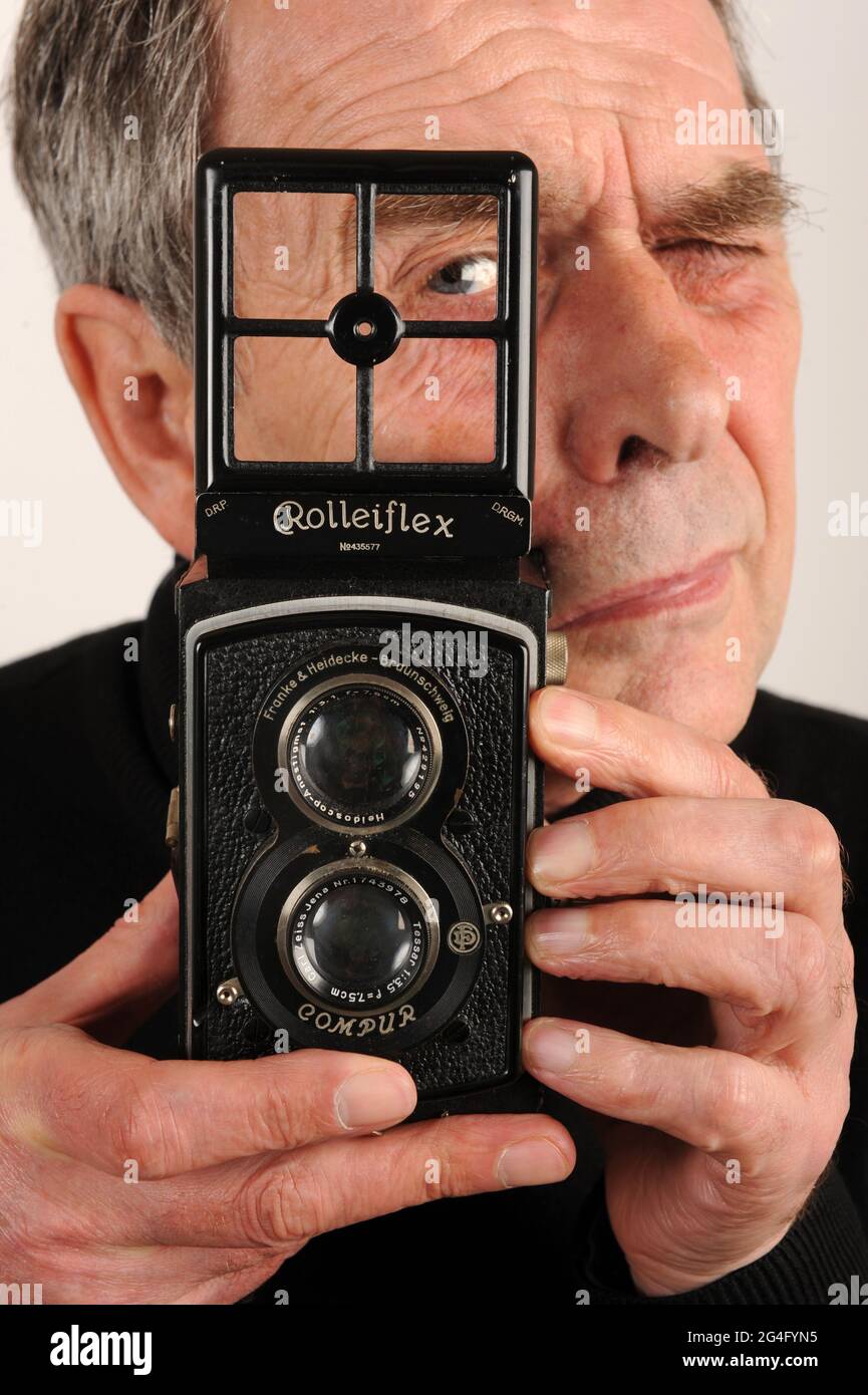 Man male photographer using a 1930s Rolleiflex twin lens reflex camera. Standard Rolleiflex 6x6 K2  twin lens reflex camera made in 1932 Stock Photo