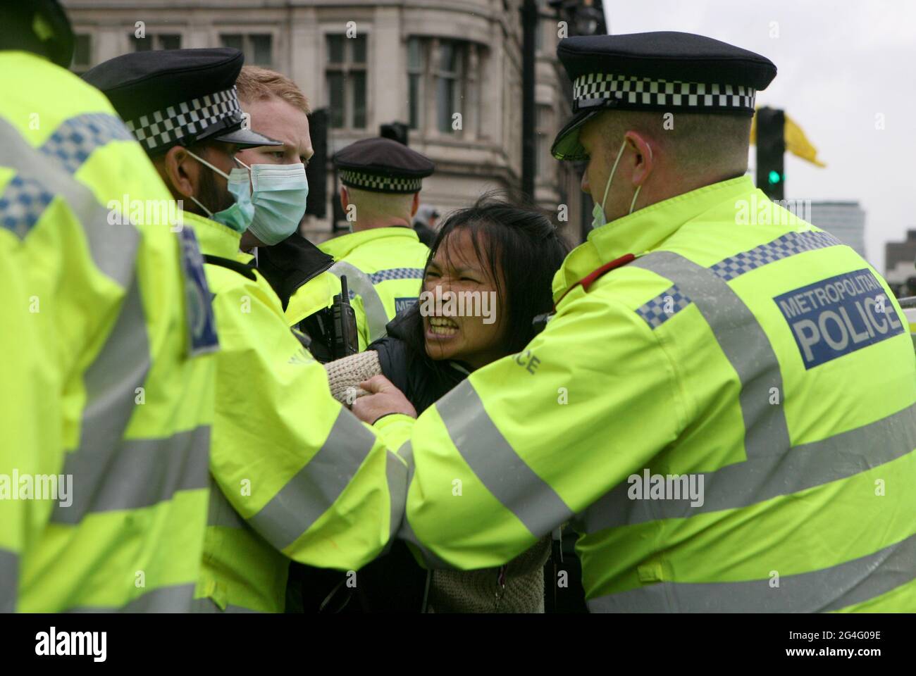 A protester is led away by police officers at an anti-lockdown protest in Parliament Square, London. Picture date: Monday June 21, 2021. Stock Photo