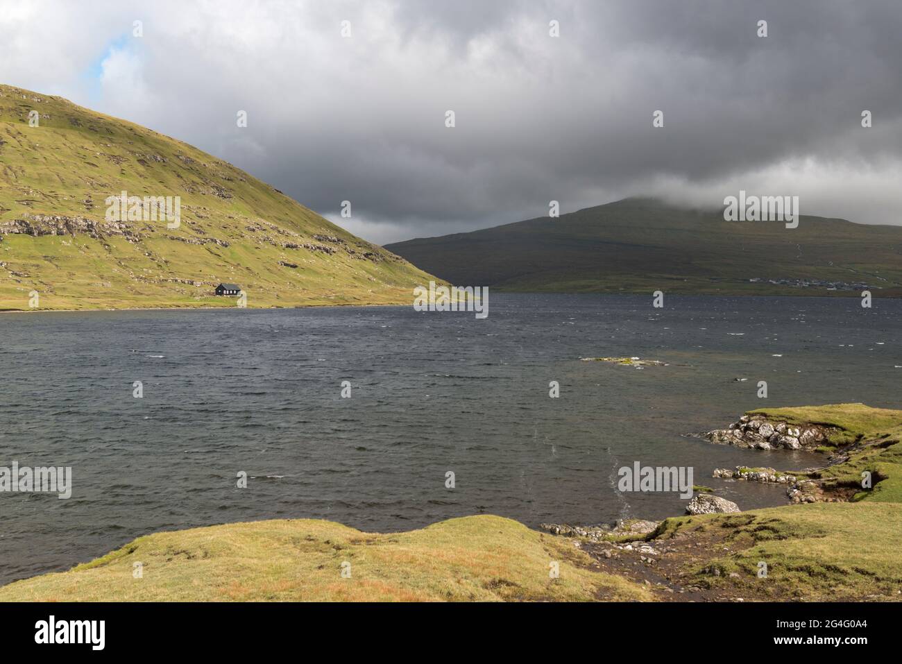 A tiny house on the shores of lake Sorvagsvatn as seen form the Traelanipa walking trail on the island of Vagar in the Faroe Islands Stock Photo