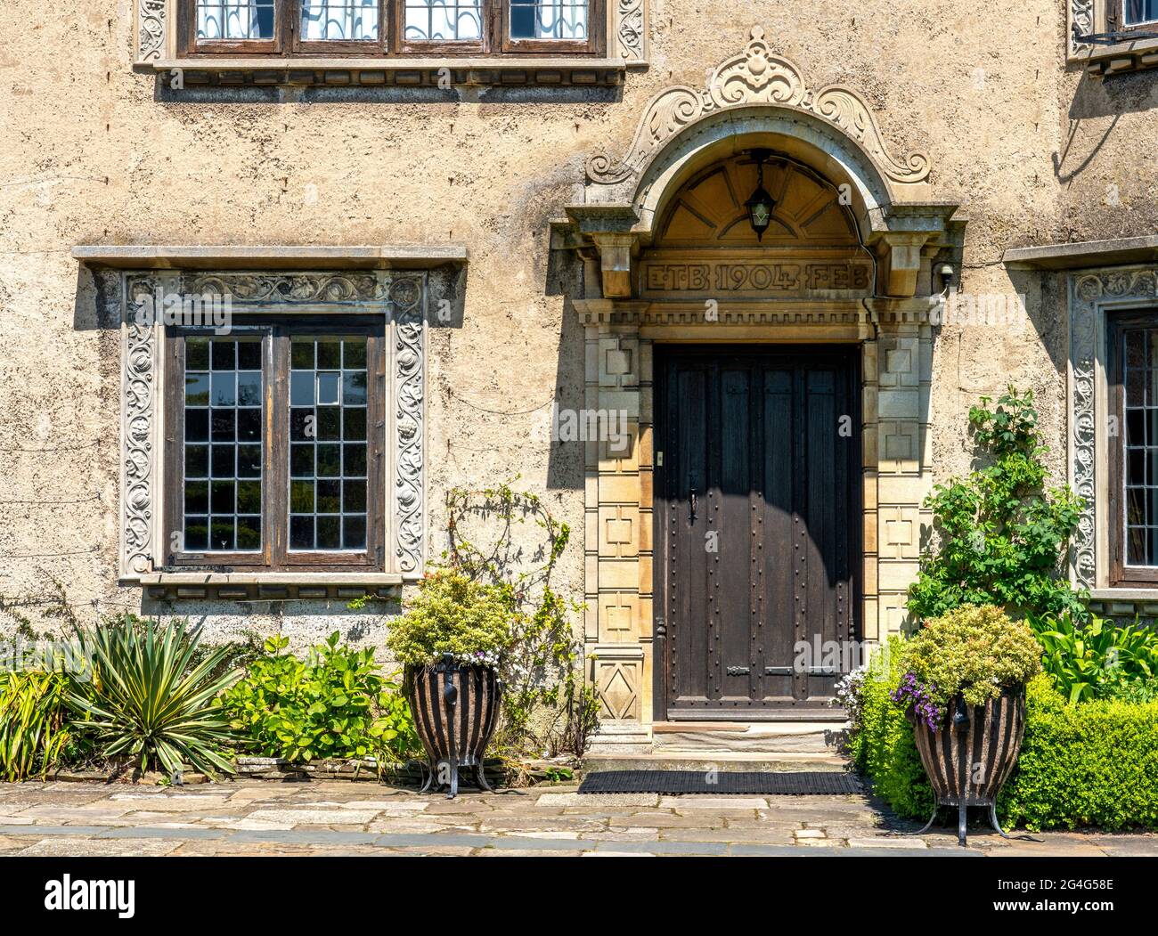 Front door of How Hill house in Norfolk UK with decorated window and door frames and arched stone canopy Stock Photo