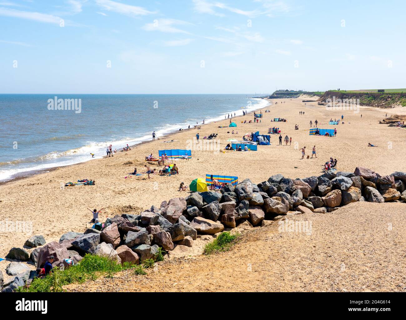 Sunny beach full of holidaymakers from clifftop at Happisburgh on the Norfolk coast UK Stock Photo