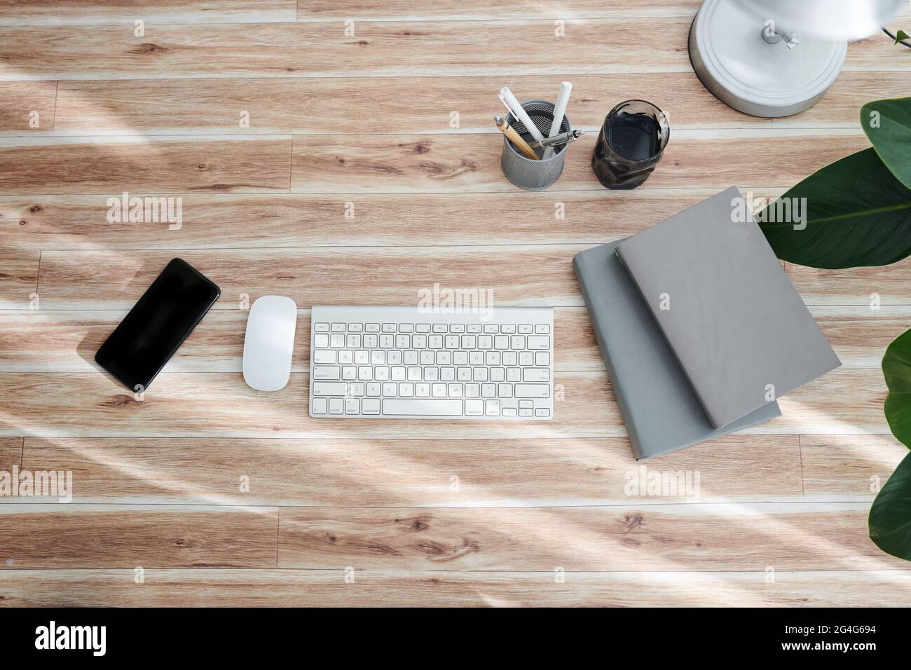 Computer keyboard, mouse, smartphone and books on office table, view from above Stock Photo