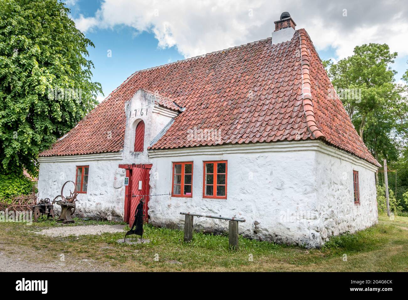 Auning, Denmark - 19 June 2021: Old smithy from the 1700s white with red windows Stock Photo