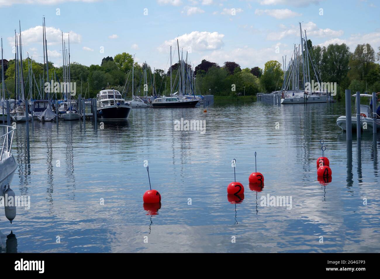 Marina in Kreuzungen with moored boats, sailing vessels and yachts. There are trees on the background and in water there are mooring buoys numbered. Stock Photo