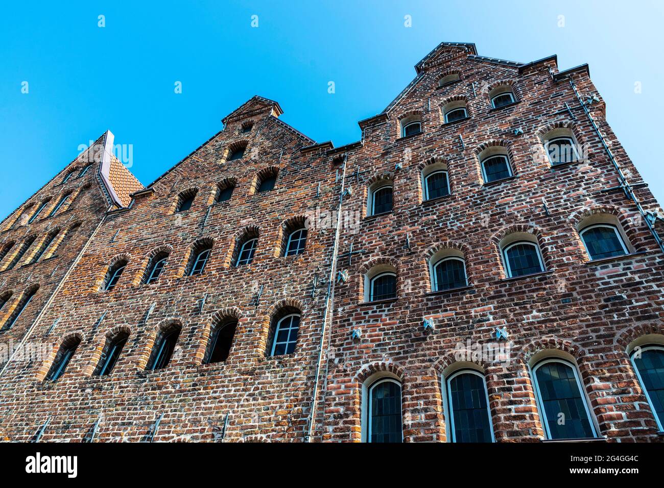 Facade of the medieval salt warehouses or Salzspeicher next to Holsten Gate or Holstentor in Lübeck, Germany Stock Photo